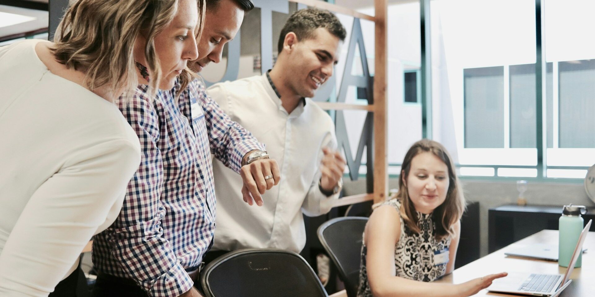 Collega’s bespreken samen een project in een moderne kantooromgeving, passend bij employer branding.