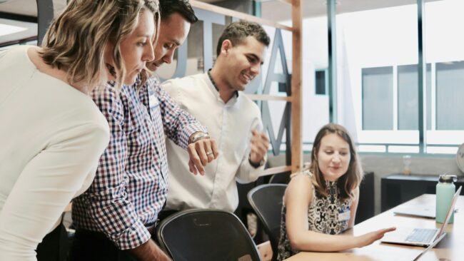 Teamoverleg in kantoorruimte Collega’s bespreken samen een project in een moderne kantooromgeving, passend bij employer branding.